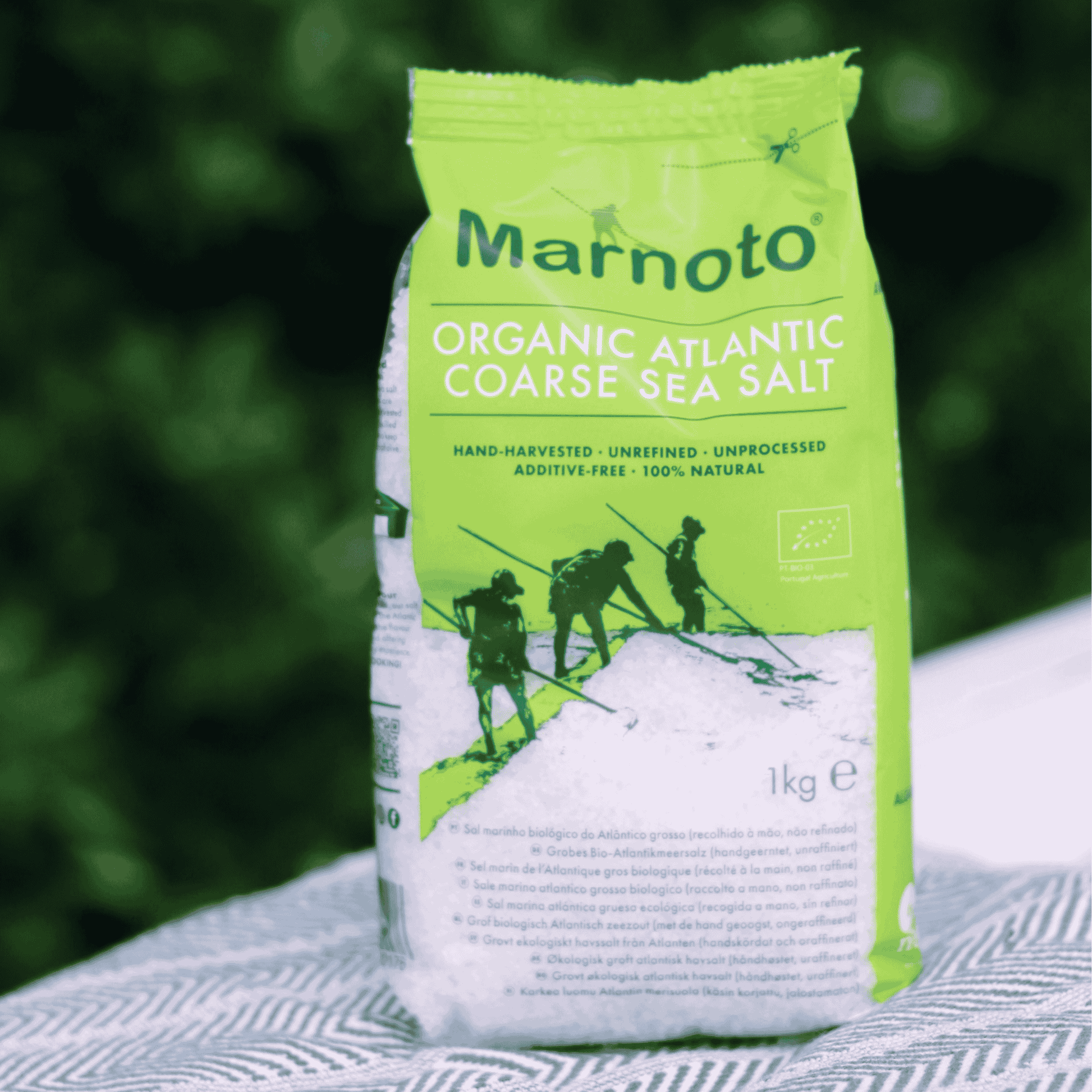 Marnoto Organic Atlantic Coarse Sea Salt packaging with green and white design on a blurred natural background