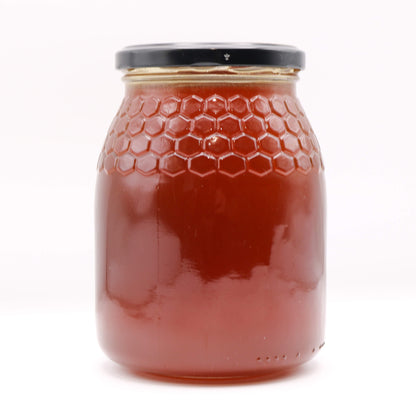 Jar of honey with a honeycomb design on a white background